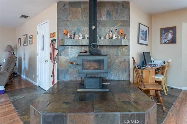 interior space featuring a wood stove and hardwood / wood-style floors