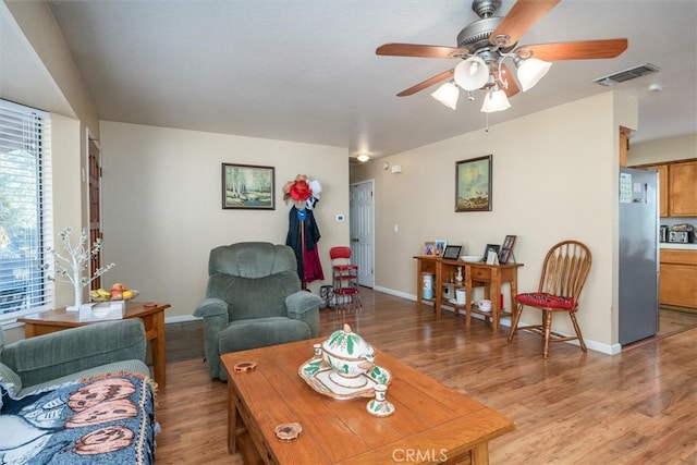 living room with light hardwood / wood-style floors and ceiling fan