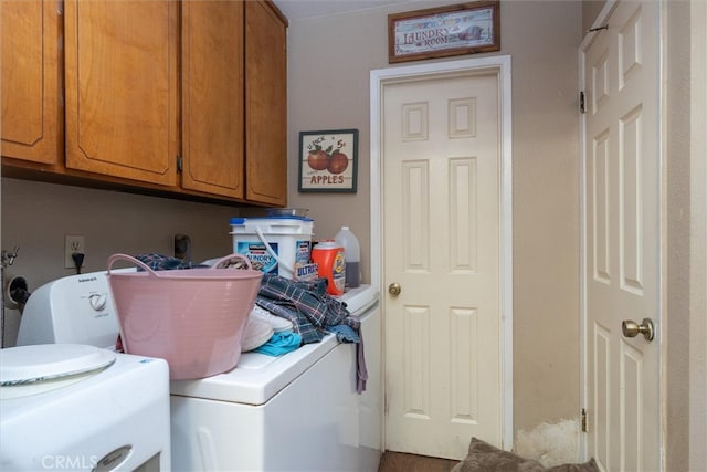 clothes washing area with cabinets and washing machine and clothes dryer