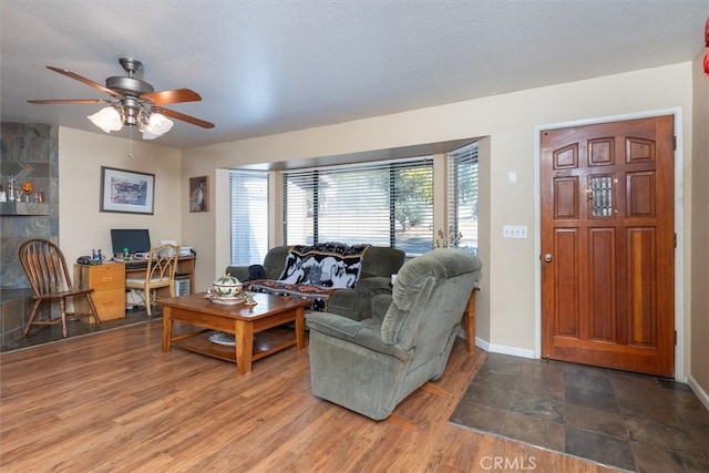 living room with ceiling fan, wood-type flooring, and a textured ceiling