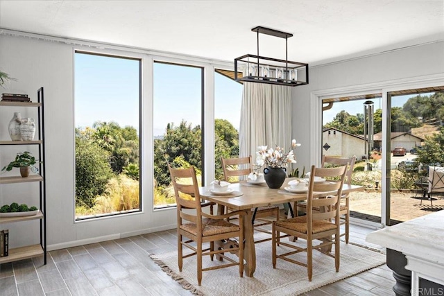 dining space featuring a healthy amount of sunlight, a chandelier, and light wood-type flooring