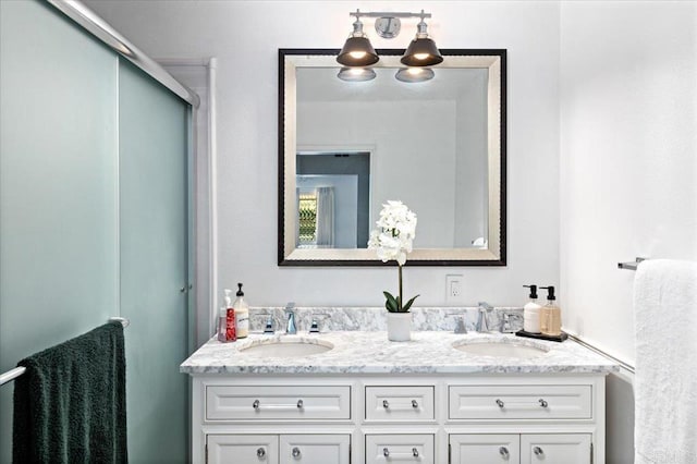 bathroom featuring a shower with door and vanity