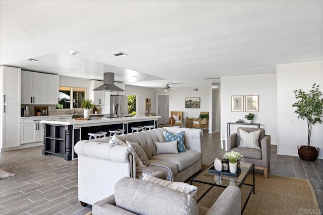 living room featuring sink, ceiling fan, and light hardwood / wood-style flooring