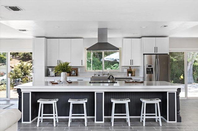 kitchen featuring a large island, white cabinetry, and stainless steel refrigerator with ice dispenser