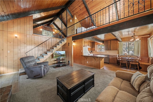 carpeted living room featuring beamed ceiling, wooden walls, high vaulted ceiling, and wooden ceiling