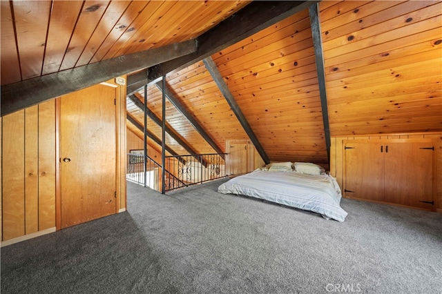 unfurnished bedroom with carpet, wooden ceiling, wooden walls, and vaulted ceiling with beams