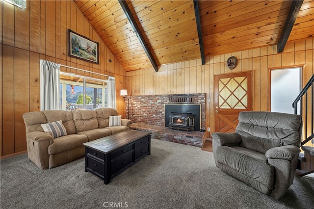 living room with a wood stove, beam ceiling, wooden walls, and carpet flooring