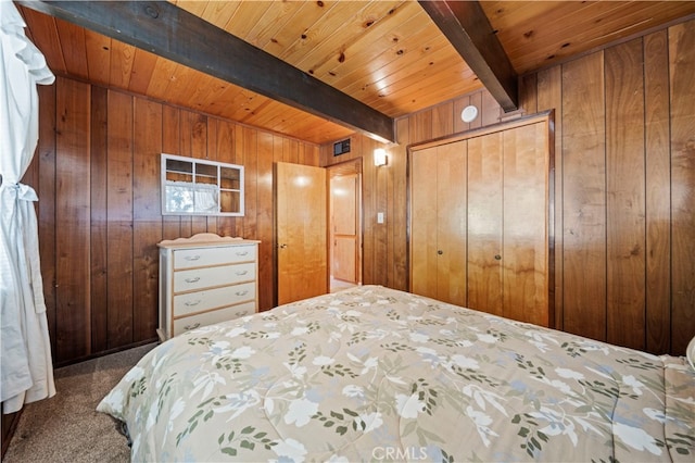 bedroom featuring wood ceiling, beam ceiling, carpet, wood walls, and a closet