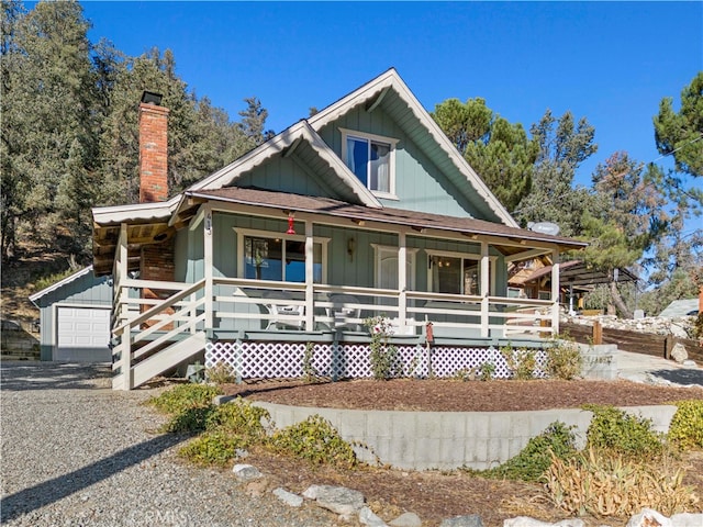 view of front of home with a porch, an outbuilding, and a garage