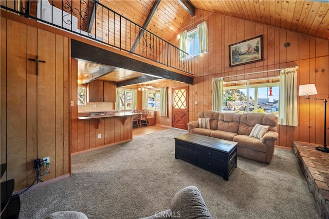 living room with wood ceiling, beamed ceiling, carpet, and wooden walls