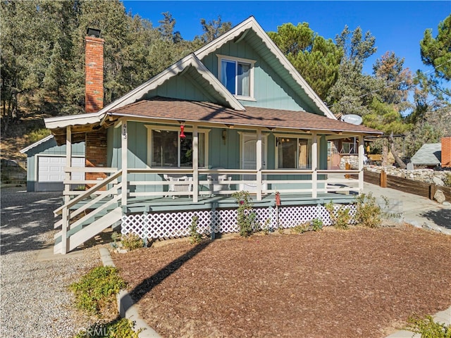 view of front of home with covered porch, an outbuilding, and a garage