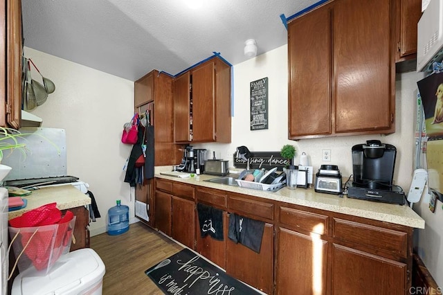 kitchen featuring sink, a textured ceiling, and dark hardwood / wood-style floors