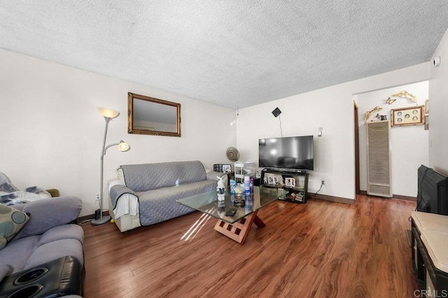 living room with dark wood-type flooring and a textured ceiling