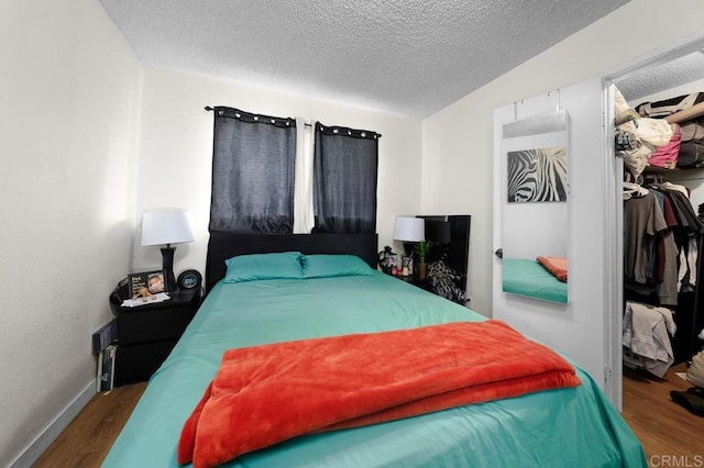 bedroom with wood-type flooring and a textured ceiling