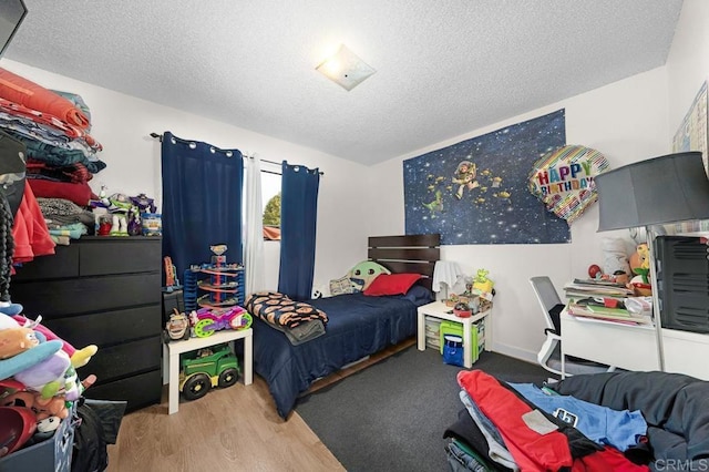 bedroom with a textured ceiling and wood-type flooring