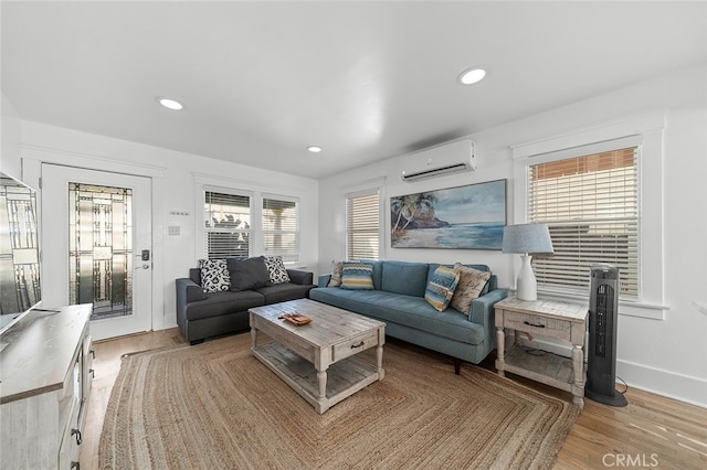 living room featuring hardwood / wood-style floors and a wall mounted AC