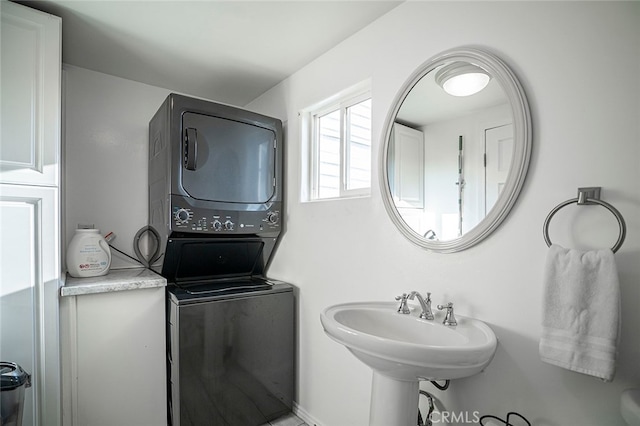 bathroom featuring stacked washer and dryer and sink