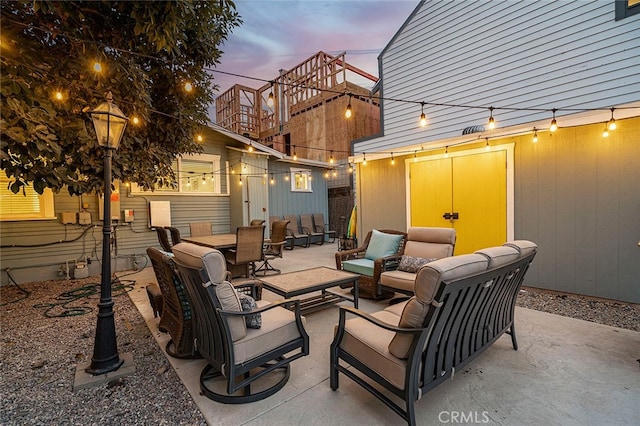 patio terrace at dusk with a balcony and an outdoor living space