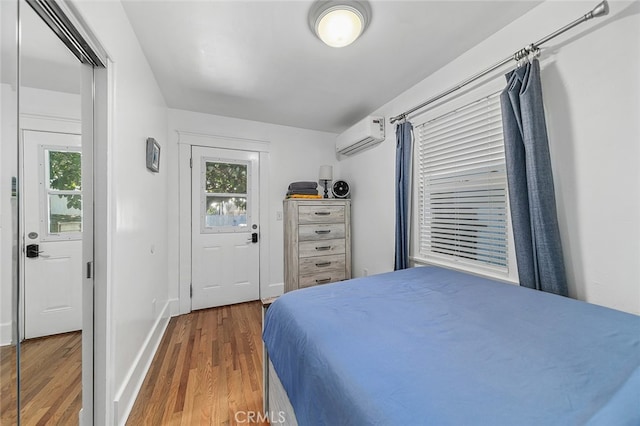 bedroom featuring wood-type flooring and a wall unit AC