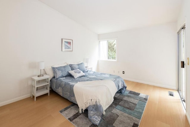 bedroom featuring hardwood / wood-style flooring and lofted ceiling