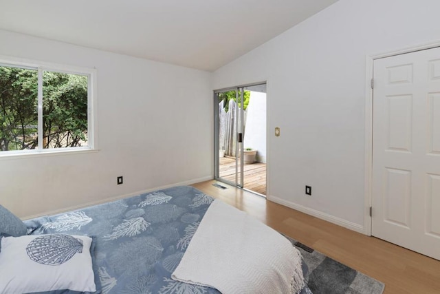 bedroom featuring lofted ceiling and light wood-type flooring