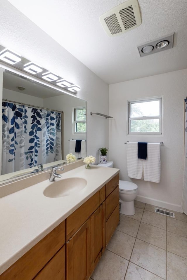 bathroom featuring tile patterned flooring, vanity, toilet, and a textured ceiling