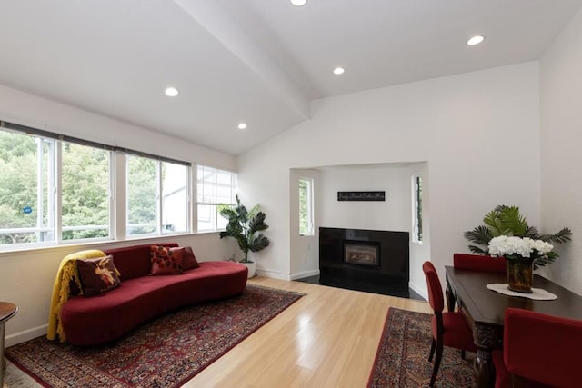 living room featuring a fireplace, lofted ceiling with beams, and hardwood / wood-style flooring