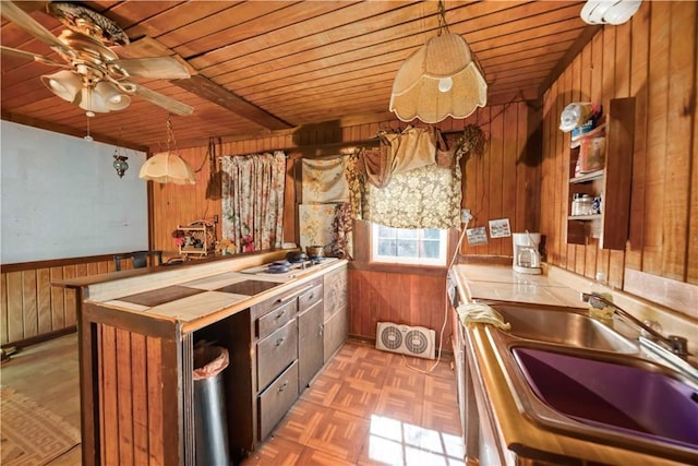 kitchen featuring pendant lighting, dark parquet flooring, wooden walls, ceiling fan, and wood ceiling