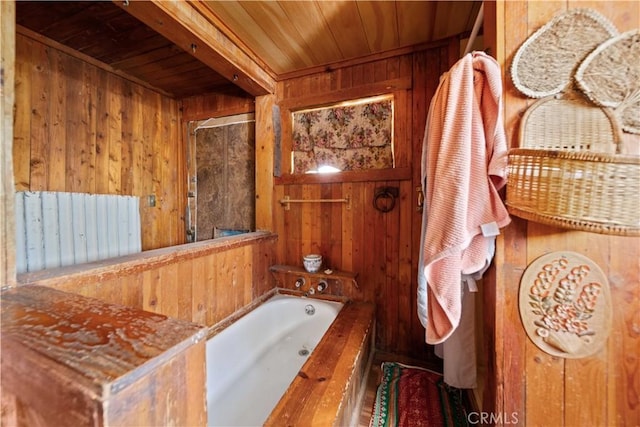 bathroom with wood walls, wooden ceiling, and a bath