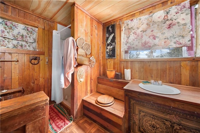 bathroom with wood walls, vanity, and wooden ceiling