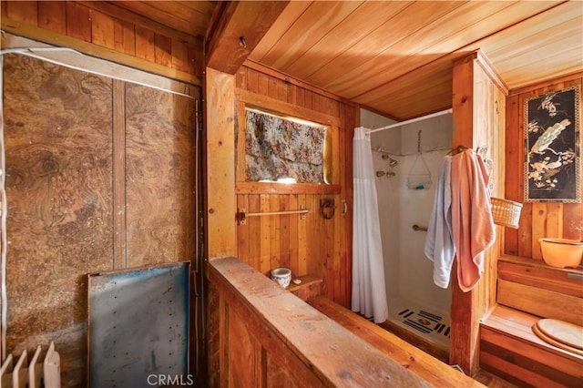 bathroom featuring wood walls, wood ceiling, and radiator heating unit