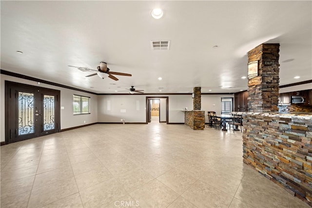 unfurnished living room featuring crown molding, light tile patterned flooring, ornate columns, and ceiling fan