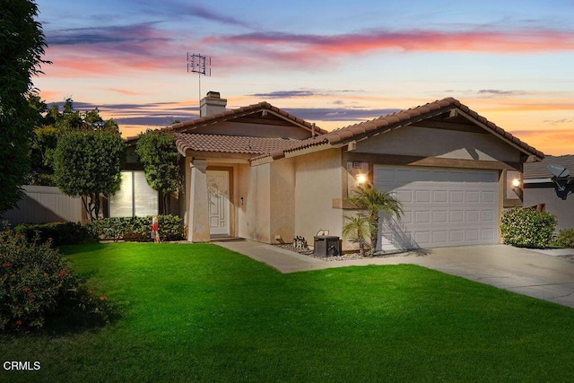 view of front facade with a garage and a lawn