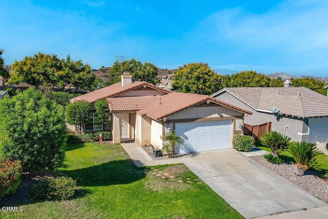 view of front of property with a mountain view, a front lawn, and a garage