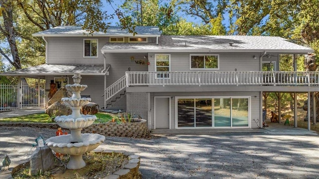 rear view of house featuring a wooden deck and a patio area