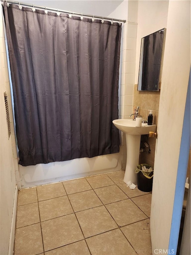 bathroom featuring tile patterned flooring, shower / bathtub combination with curtain, and sink