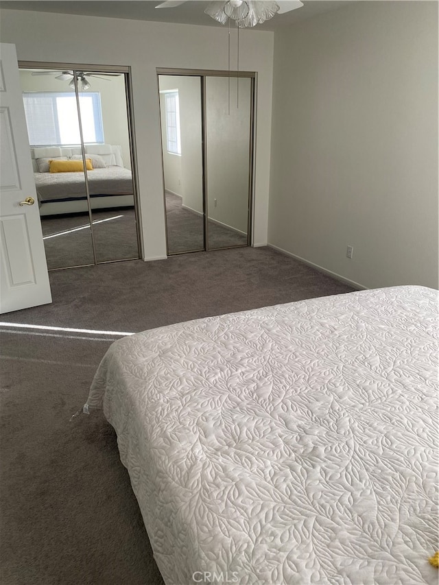 unfurnished bedroom featuring two closets, carpet floors, and ceiling fan