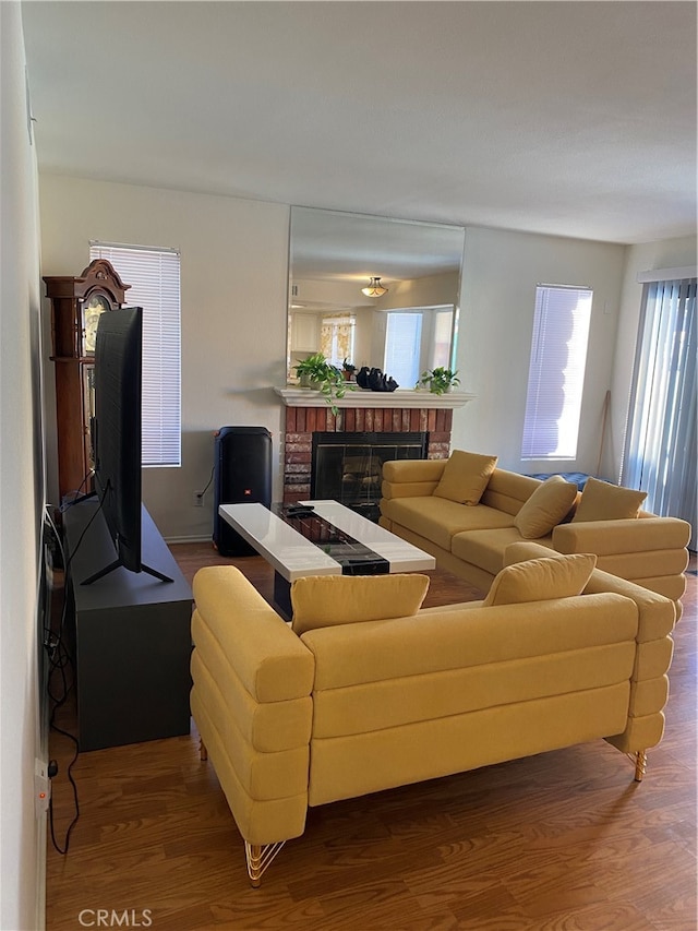 living room with wood-type flooring and a brick fireplace