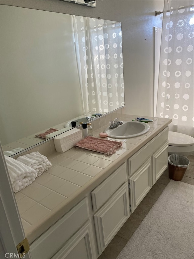 bathroom with vanity, toilet, and tile patterned flooring