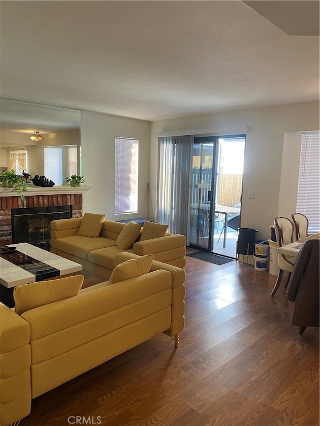 living room featuring a brick fireplace and dark hardwood / wood-style floors