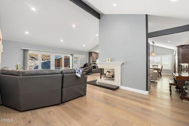 living room with beamed ceiling, high vaulted ceiling, and light wood-type flooring