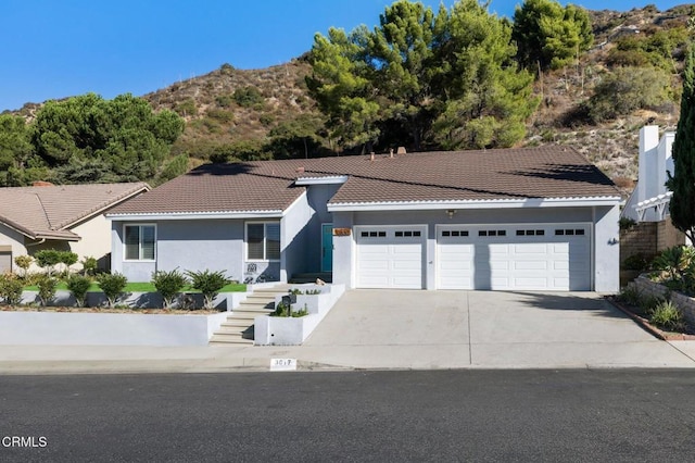 ranch-style house with a mountain view and a garage