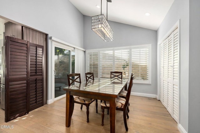 dining space featuring light hardwood / wood-style floors and high vaulted ceiling