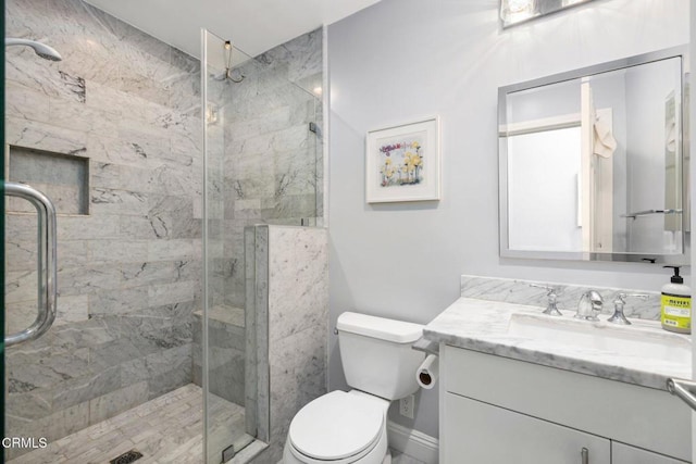 bathroom with vanity, a shower with shower door, and toilet