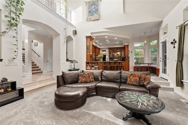 living room with light colored carpet and a towering ceiling