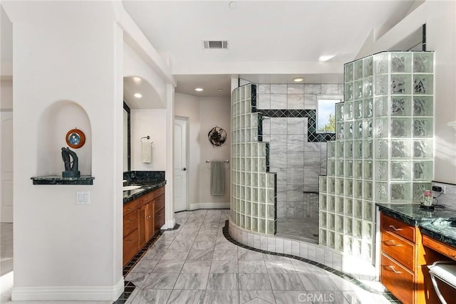 bathroom featuring a tile shower and vanity