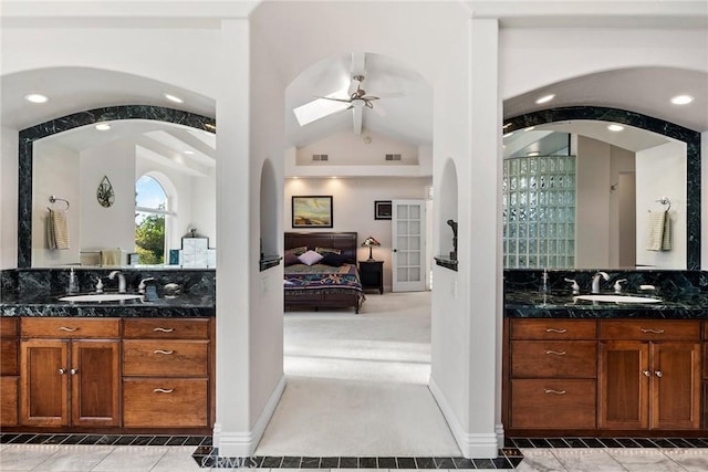 bathroom featuring ceiling fan, vanity, and lofted ceiling