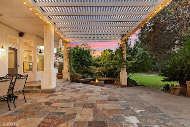 patio terrace at dusk featuring a fire pit and a pergola