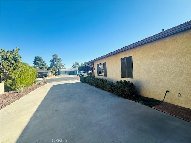 view of property exterior with a patio area