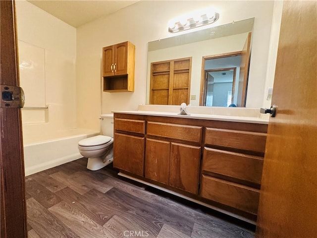 full bathroom with bathing tub / shower combination, vanity, hardwood / wood-style flooring, and toilet